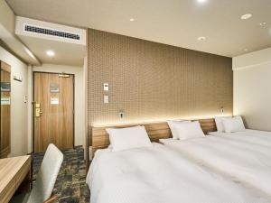 A bed or beds in a room at Hotel Elcient Kyoto Hachijoguchi