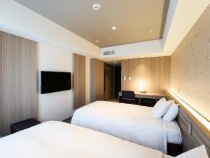 A bed or beds in a room at Hotel Elcient Kyoto Hachijoguchi