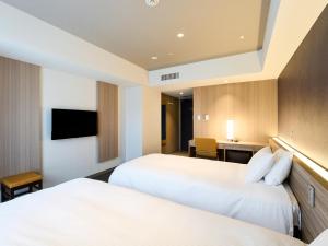 A bed or beds in a room at Hotel Elcient Kyoto Hachijoguchi