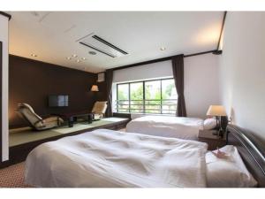 A bed or beds in a room at Hotel Silk Onsen Yamabiko