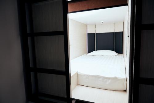 a bedroom with a bed in a mirror at Hotel Kapsula in Astana