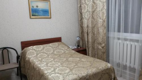 a small bedroom with a bed and a window at Hotel Shagyn in Astana