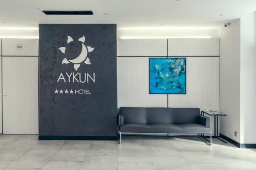 a couch in a room with a sign on a wall at AYKUN Hotel by AG Hotels Group in Astana