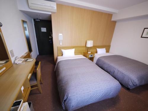 Ліжко або ліжка в номері Hotel Route-Inn Oita Ekimae