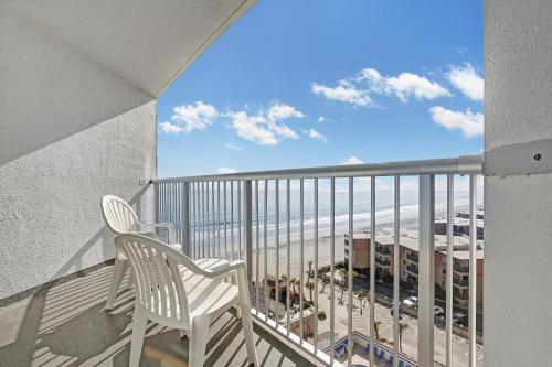 einen Balkon mit einem Stuhl und Strandblick in der Unterkunft Ocean Annie's Resorts in Myrtle Beach