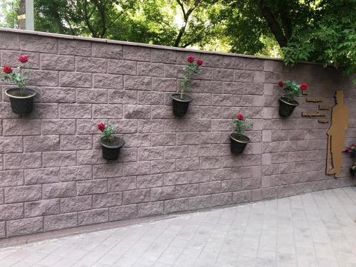 a brick wall with potted plants on it at Brown Hotel in Astana