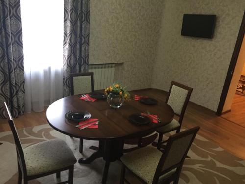 a dining room with a table with chairs and a television at Sultan Beibarys in Astana