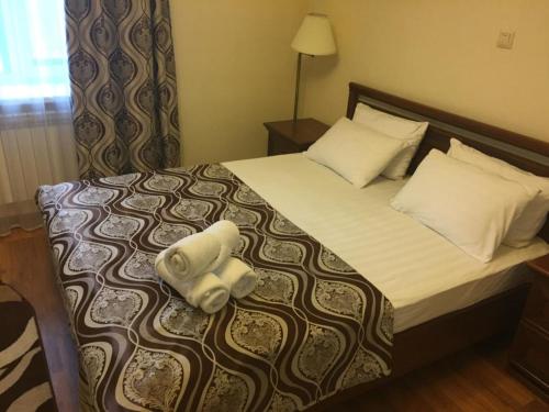 a hotel room with a bed with two towels on it at Sultan Beibarys in Astana