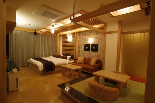 a bedroom with a bed and a couch and a table at Hotel & Spa Lotus (Adult Only) in Kyoto