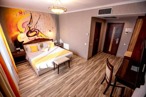 a bedroom with a bed and a table and a desk at G Empire in Astana