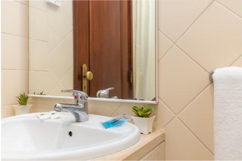 bagno con lavandino e specchio di Hotel Residencial Colibri a Costa da Caparica