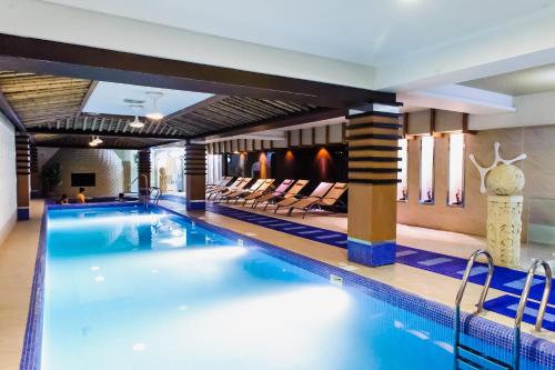 a swimming pool in a hotel with chairs in it at Diplomat Hotel by AG Hotels Group in Astana