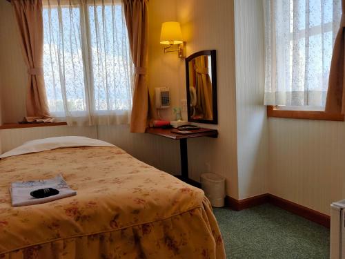 Pokój hotelowy z łóżkiem i lustrem w obiekcie Beppu Station Hotel w mieście Beppu