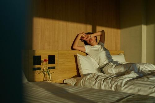 een vrouw in bed met haar hoofd op een kussen bij fav KUMAMOTO in Kumamoto