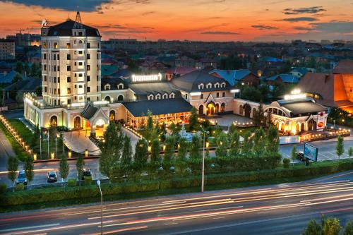 a large white building with a clock tower at night at Boutique Hotel Traditional in Astana