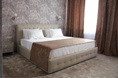 a bedroom with a large bed with white pillows at MirOtel Hotel in Astana