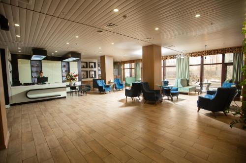 a lobby with chairs and tables and a waiting room at Altyn Eco Park in Astana