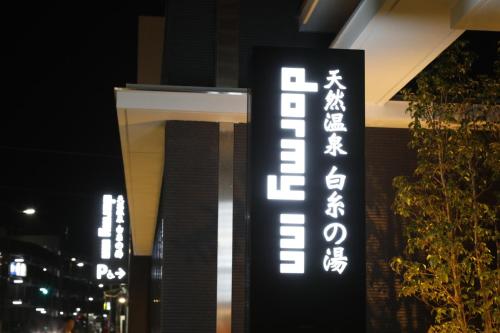 ein Gebäude mit einem Schild, auf dem das Hotel steht in der Unterkunft Dormy Inn Oita in Ōita