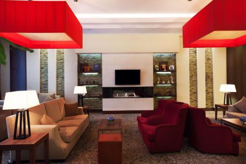 a living room with two couches and a television at Hilton Garden Inn Astana in Astana