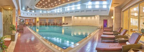 a large swimming pool in a large building at Rixos President Hotel Astana in Astana