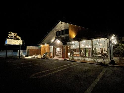 a building lit up at night with lights at Asobe in Aso