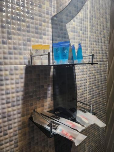 a glass shelf in a bathroom with a mirror at Baiterek Premium in Astana