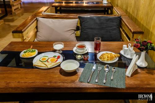 a tray of breakfast food on a wooden table at Brown Hotel in Astana