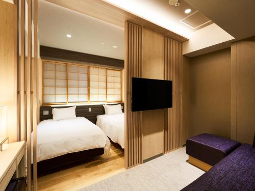 A bed or beds in a room at Hotel Elcient Kyoto Hachijoguchi