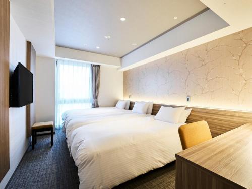 A bed or beds in a room at Hotel Elcient Kyoto Hachijoguchi