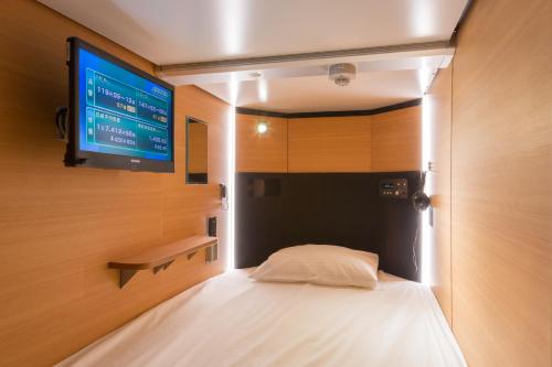 A bed or beds in a room at Sauna & Capsule Hotel Rumor Plaza