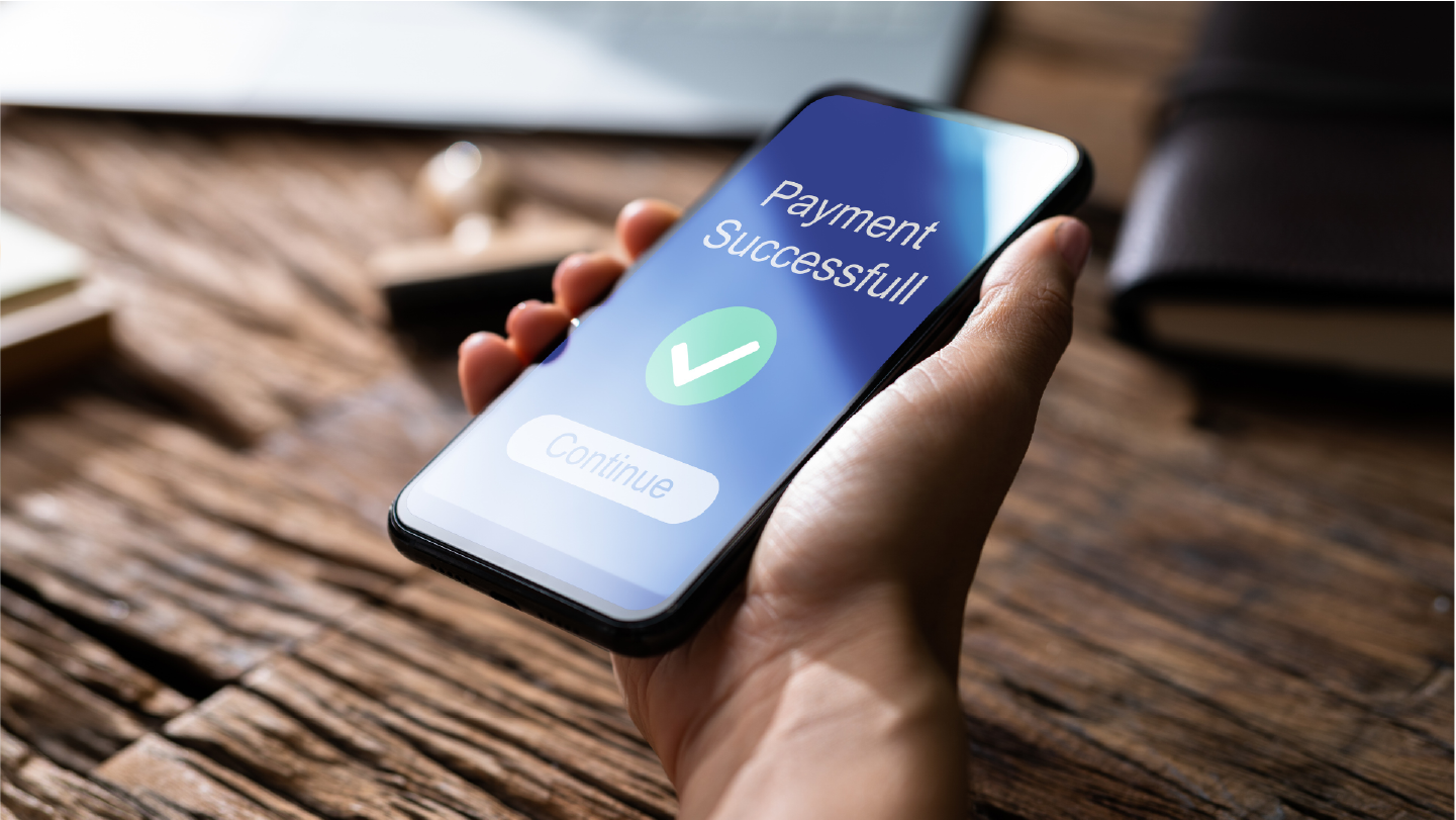 Person holding a phone that says Payment Successful
