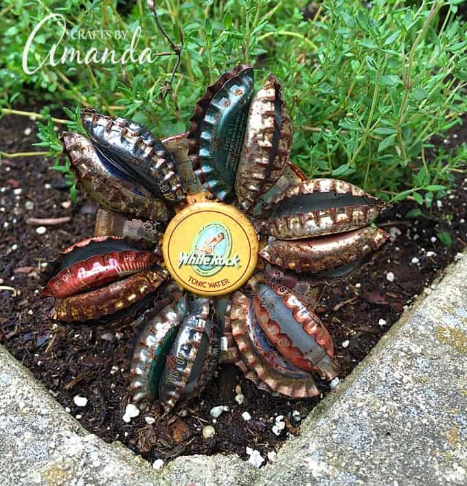 Turn old bottle caps into a rustic bottle cap flower to display in potted plants or right in your garden. Safe to leave outside too! #bottlecap #recycledcrafts #gardencrafts #adultcrafts #recycle #repurpose #earthday #summercrafts #springcrafts Bottle Cap Flower