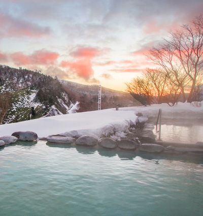 A Body Of Water With Snow And Trees Around It