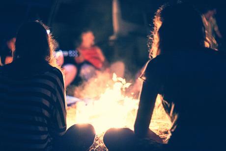 Teenagers sitting around a campfire