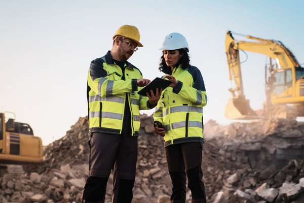 Workers using construction software on site 