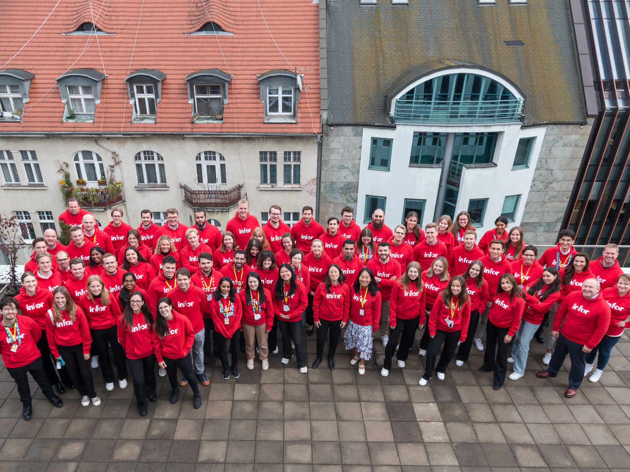 Infor team on the terrace of an office building, wearing matching Infor sweatshirts 