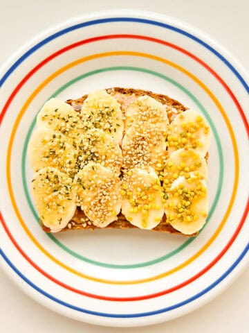 An image of banana supreme toast on a rainbow coloured plate.