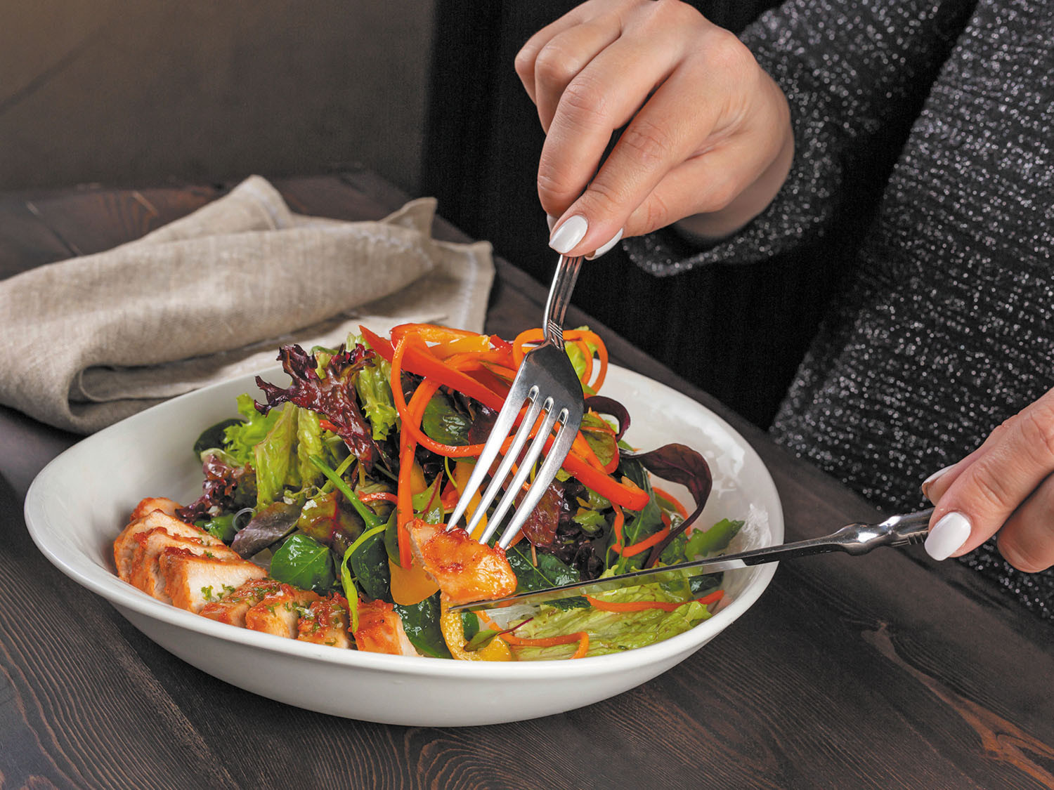 A woman eating a salad with a fork