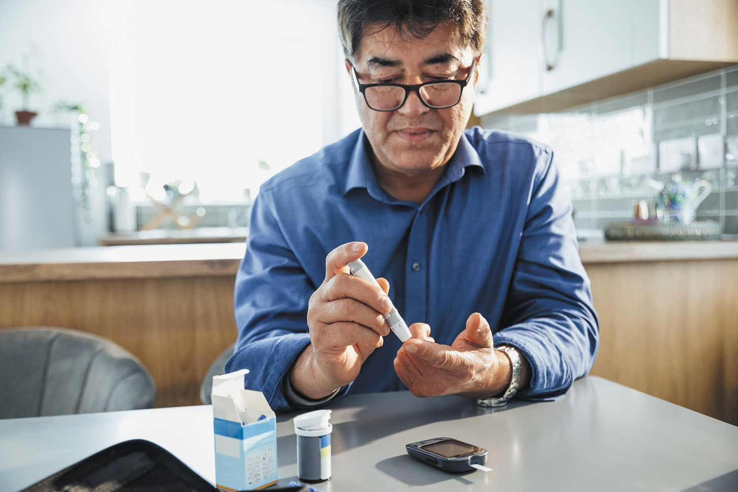 A man sitting at a table performing glucose test