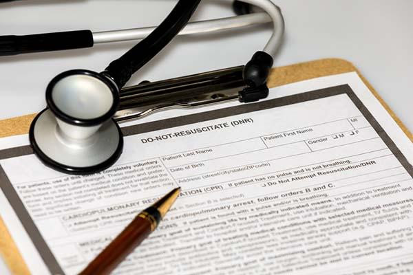 A blank do not resuscitate document on a clipboard, with a stethoscope and pen resting on it.