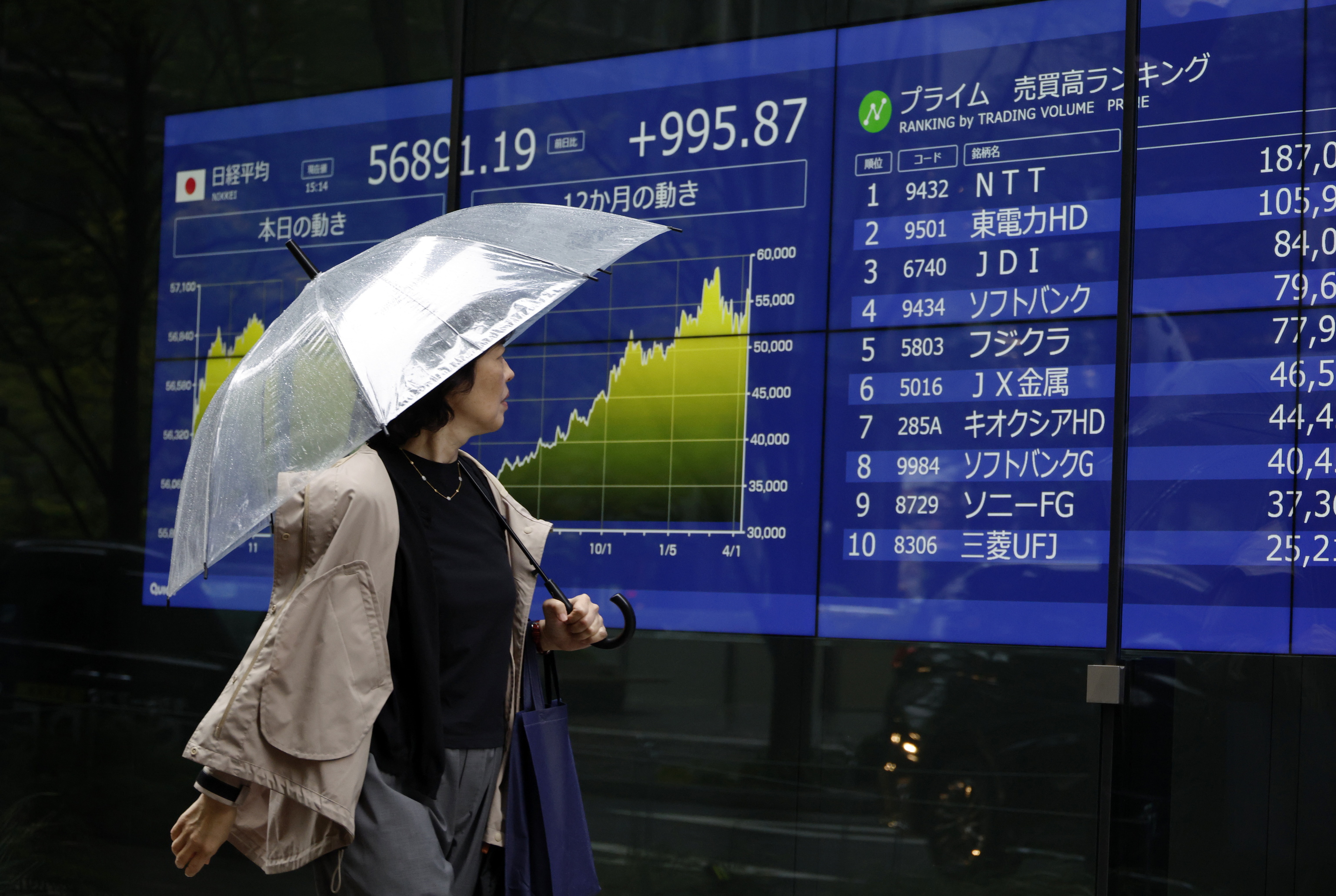 Una persona camina por delante de las pantallas que reflejan la cotizaci�n de la Bolsa de Tokio, el 10 de abril, en Tokio (Jap�n).