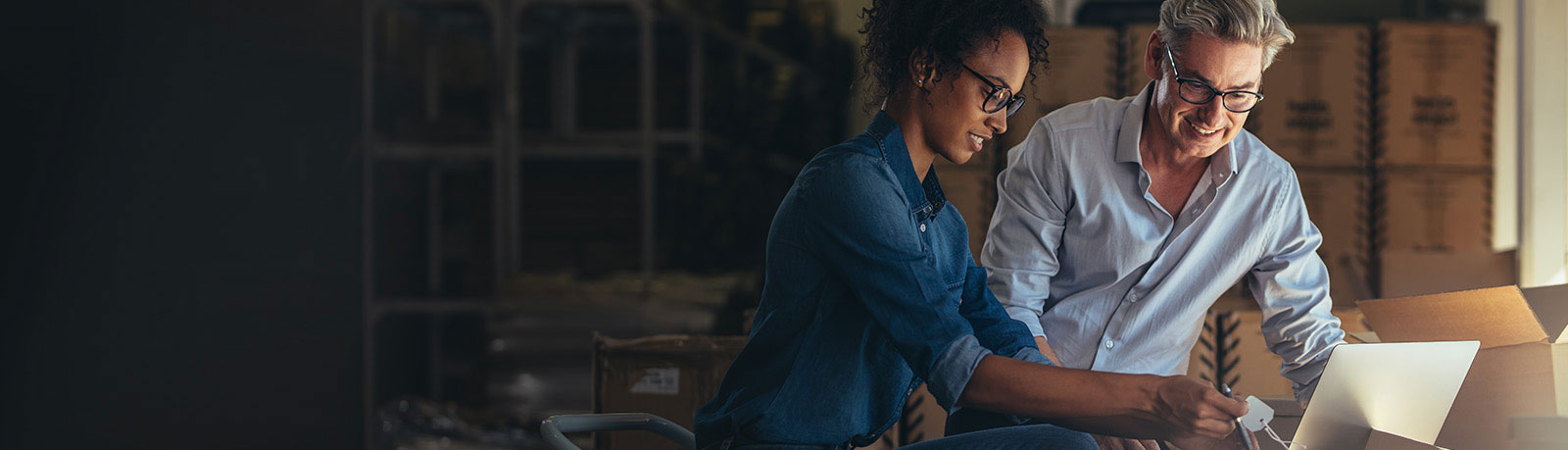 Man and woman checking price of item while looking at monitor