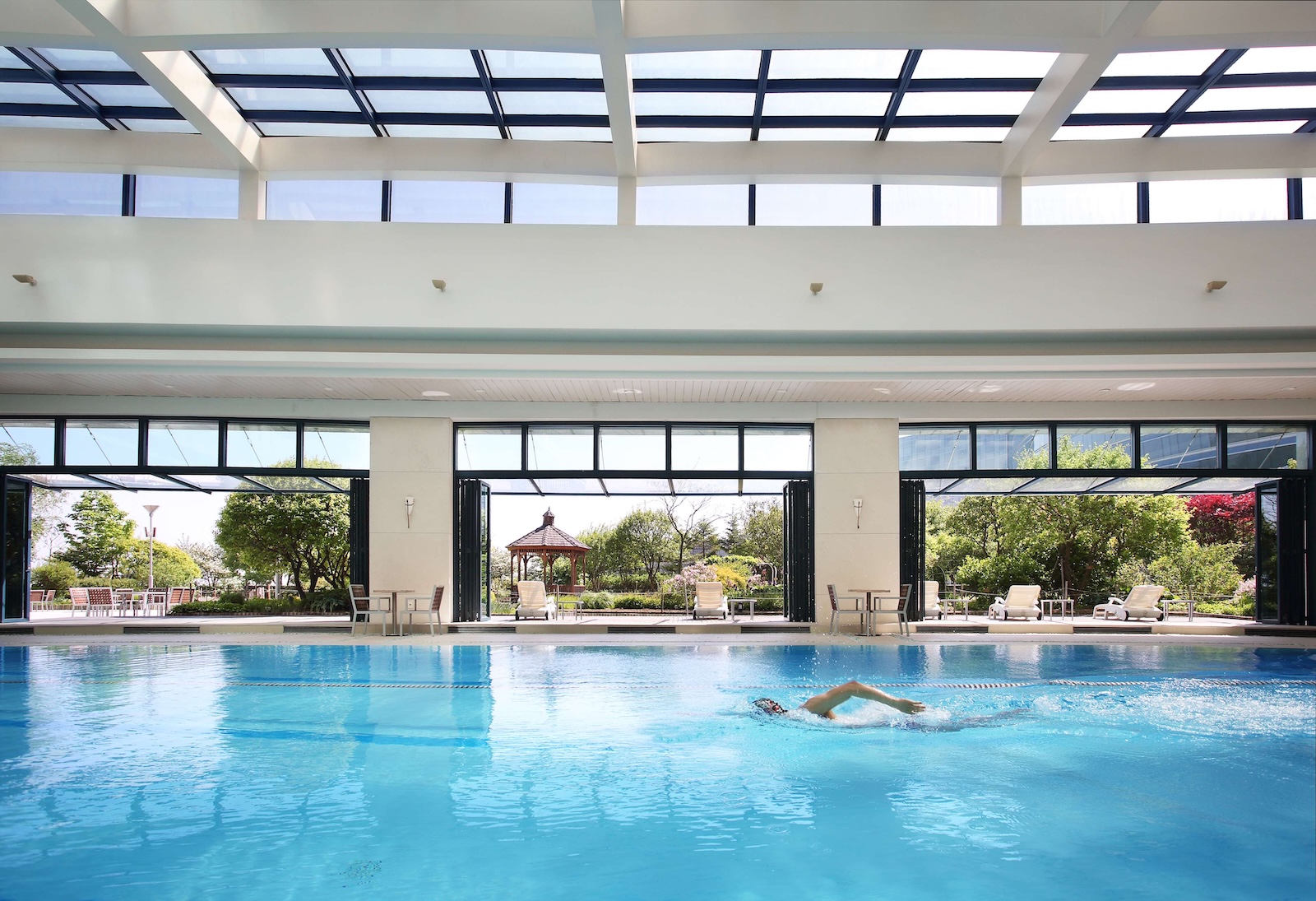 A spacious indoor swimming pool at the Grand Hyatt Incheon, surrounded by elegant architecture and natural light.