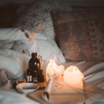 Candles and books are laid on a bed