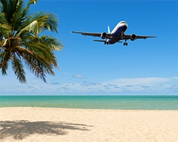 A photo of an airplane flying over a tropical island.