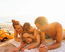 A mother, father, and their two sons enjoy the beach.