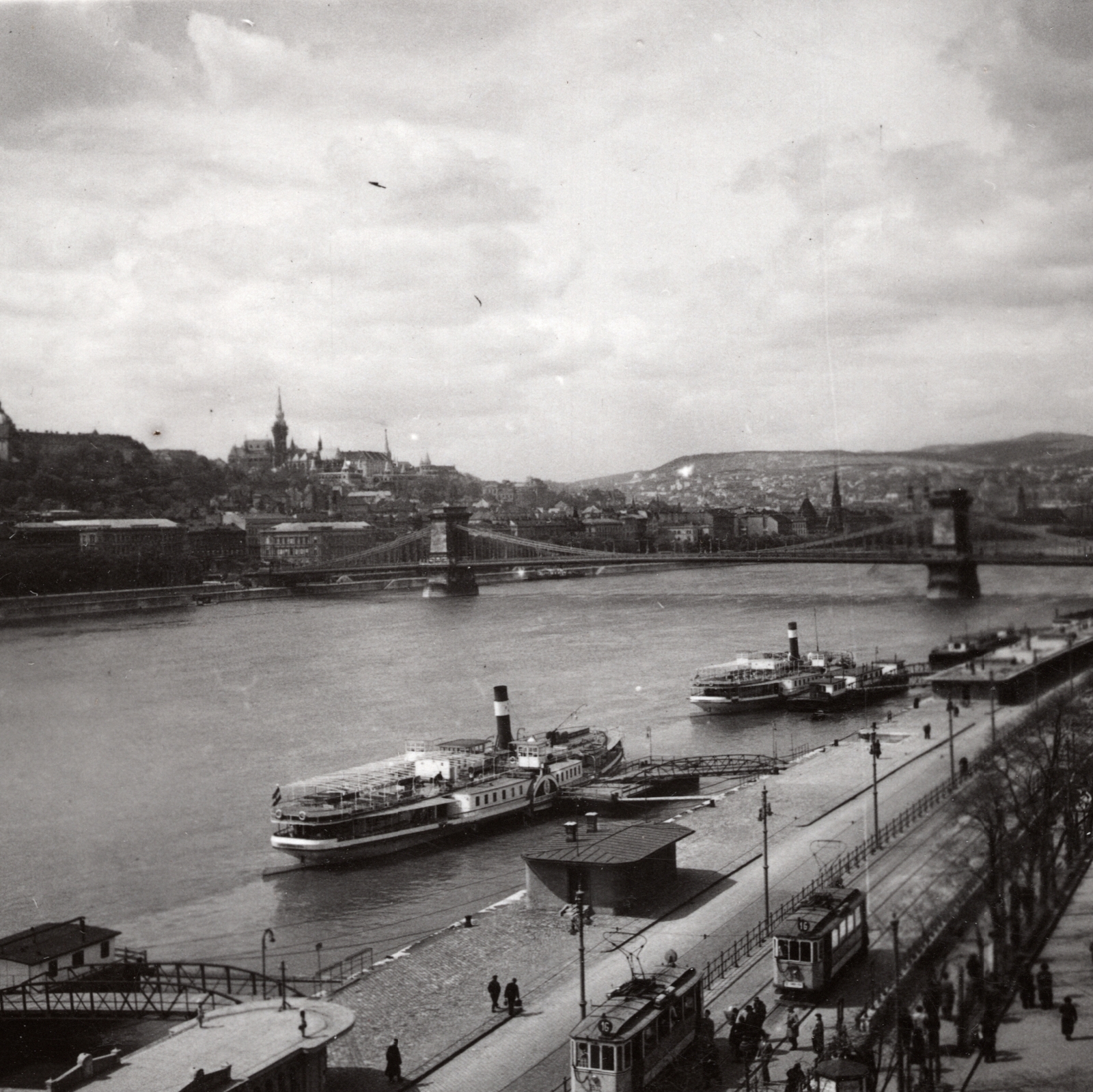 Magyarország, Budapest V.,Budapest I., Dunakorzó és a Vigadó téri hajóállomás a Duna szállóból nézve, háttérben a budai Vár és a Széchenyi Lánchíd. Előtérben a József Főherczeg (későbbi Dömös) oldalkerekes gőzhajó, mögötte a Leányfalu oldalkerekes gőzhajó., 1935, Heinzely Béla, híd, villamos, gőzhajó, Budapest, Fortepan #129151