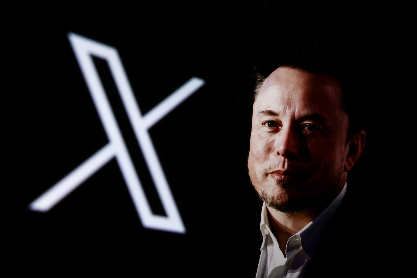 Elon Musk next to a logo for X, the social media platform formerly known as Twitter.