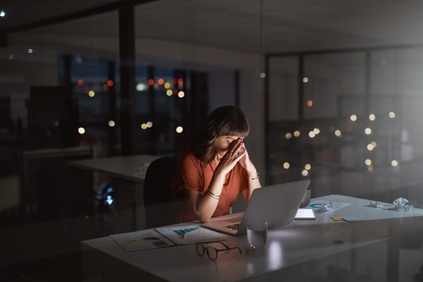 Shot of a young businesswoman looking stressed out while working on a laptop in an office at night