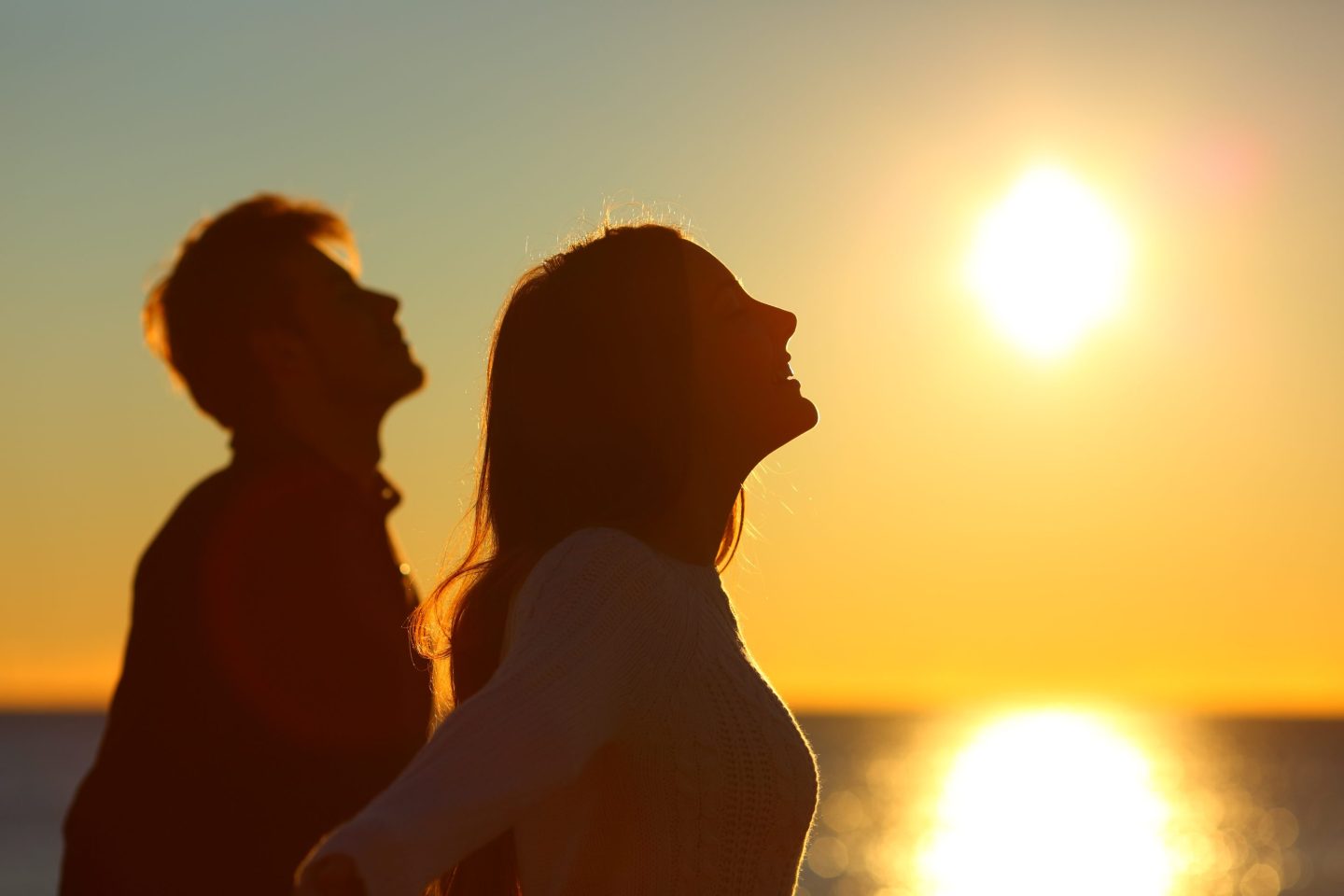 Silhouette of two people breathing fresh air at sunset